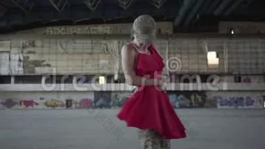 漂亮的<strong>年轻</strong>女子穿着军装，穿着红色的衣服，在废弃的建筑里翩翩起舞。 这<strong>就是</strong>